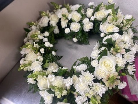 Floral wreath made of white flowers on a neutral background