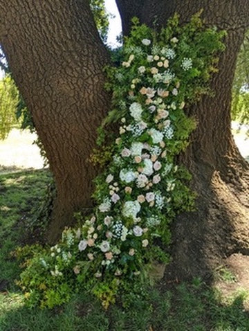 Floral arrangement draped over a tree trunk