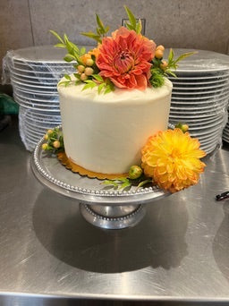 White cake with floral decorations on a metal surface