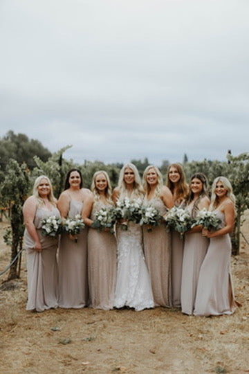 Group of women in matching dresses standing outdoors with a neutral background
