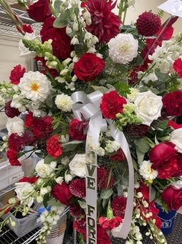 Bouquet of red and white flowers with ribbons in a store setting